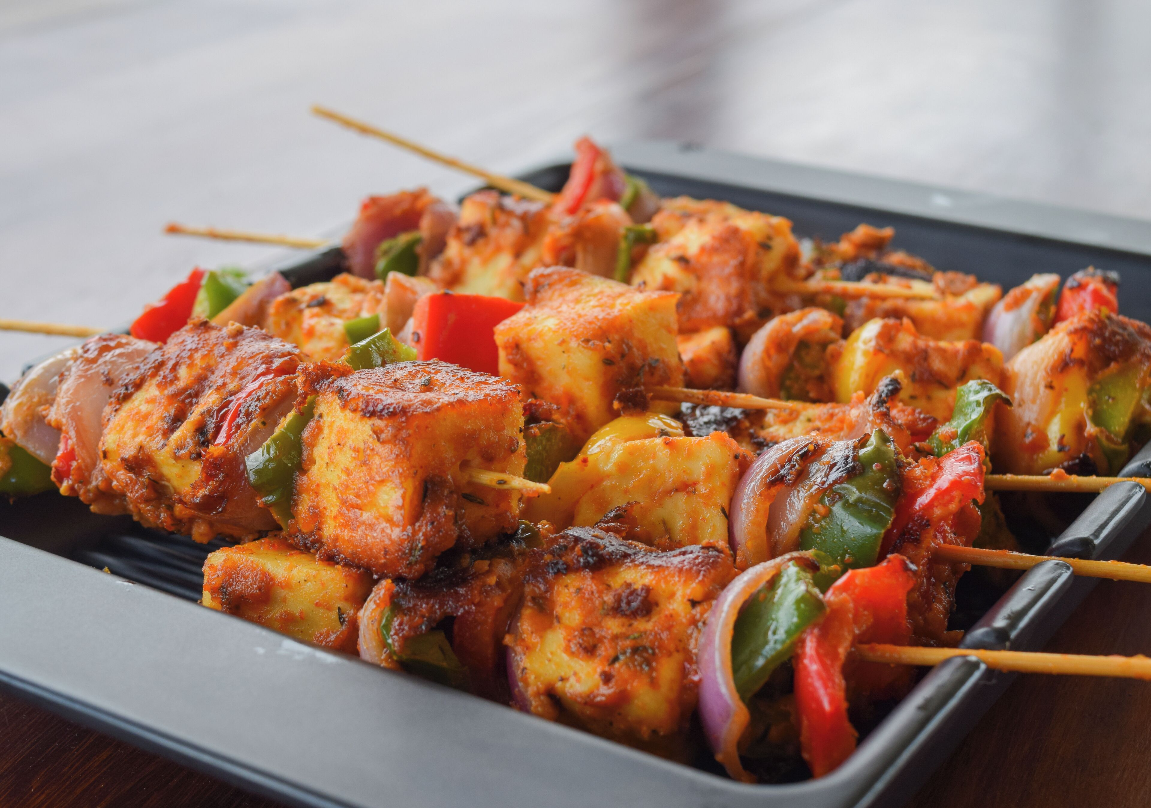 A tray of grilled paneer and vegetable skewers.