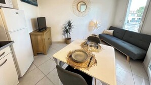 Un espacio habitable compacto con comedor, kitchenette y zona de estar.