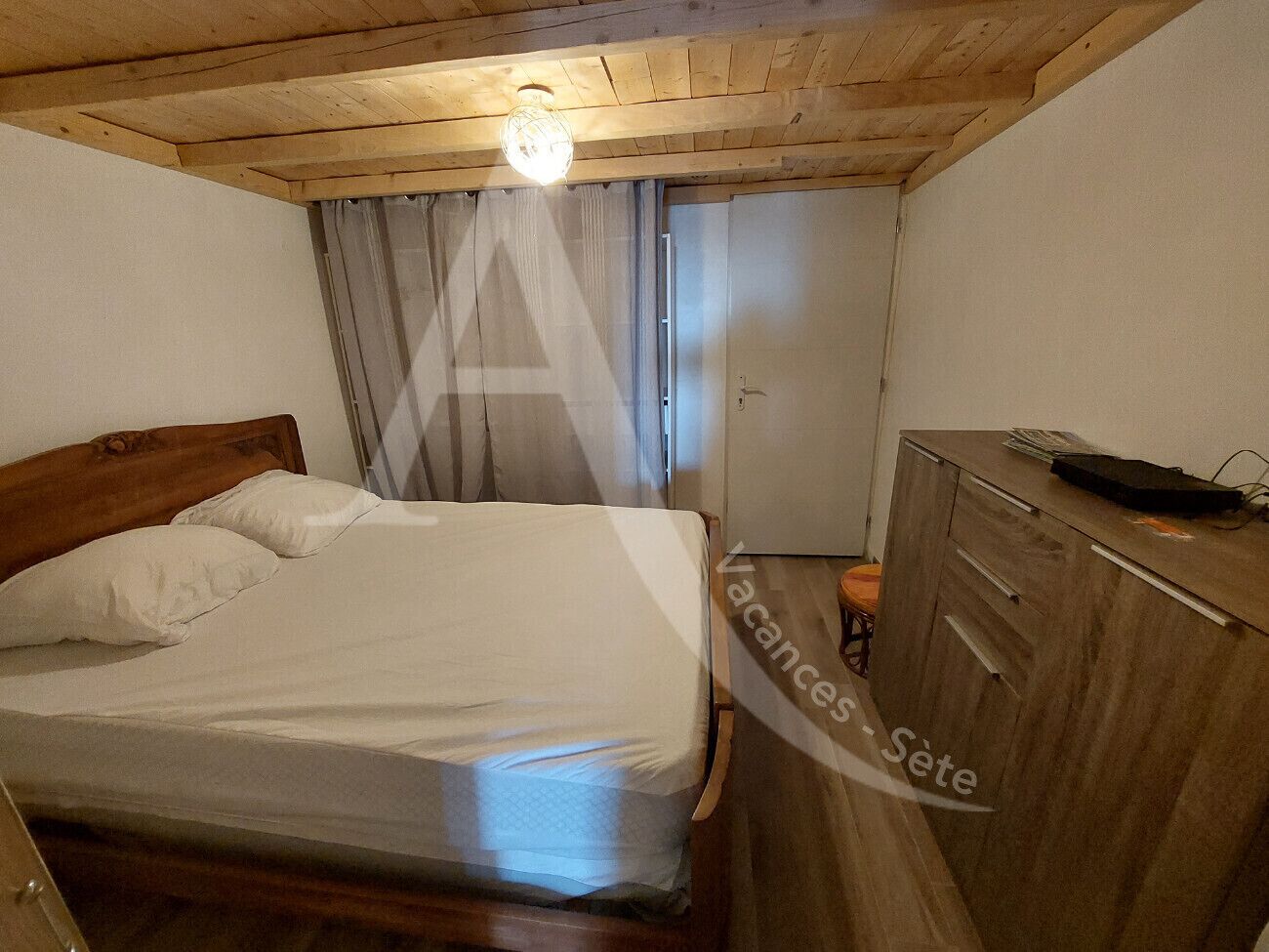 A bedroom with a wooden bed, a nightstand, and a wardrobe.