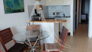 Uma cozinha compacta com área de refeições, cafeteira e uma pequena ilha.