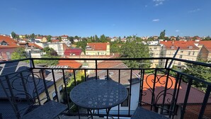 A balcony with a table and chairs, overlooking a residential area with red-roofed buildings. - Zagreb Center 2BR + 2.5BA - 104m² Loft by Cathedral (Zagreb)
