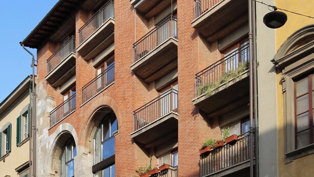 A multi-story building with balconies, stone arches, and outdoor seating. - Gialel Pisa Guest House (Pisa)