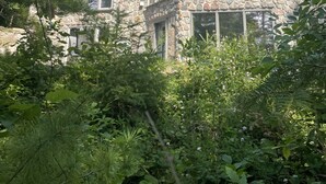 Un edificio de piedra con amplias ventanas y una chimenea de piedra.