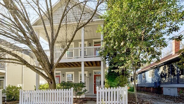 A two-story building with a porch, a white picket fence, and a tree in front. - Loft on 3rd 616: 2  BR, 2  BA Condominium in Wilmington, Sleeps 4 (Wilmington)