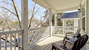A covered porch with wooden railings and two wooden chairs. - Loft on 3rd 616: 2  BR, 2  BA Condominium in Wilmington, Sleeps 4 (Wilmington)