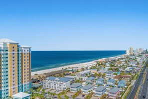 A coastal town with beachfront properties, a high-rise hotel, and a clear blue sky. - A Shore Bett ~ Gulf View Oasis with Private Pool (Panama City)