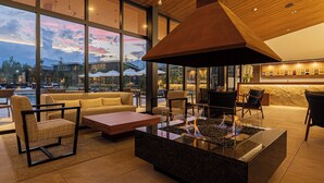 Un espace de détente moderne doté d’un foyer, de sièges confortables et d’un bar proposant une sélection de vins.