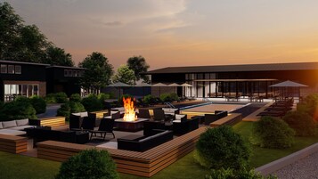 Un área de piscina moderna al aire libre, con sillones de descanso y una chimenea.