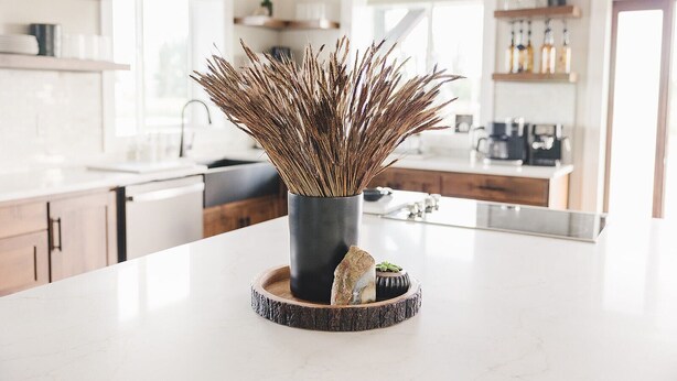 A modern kitchen with a central island, a vase with dried plants, and a rustic coaster. - COW PALACE 
Experience Rustic Charm and Tranquility at our Old Milk Barn.  (Preston)