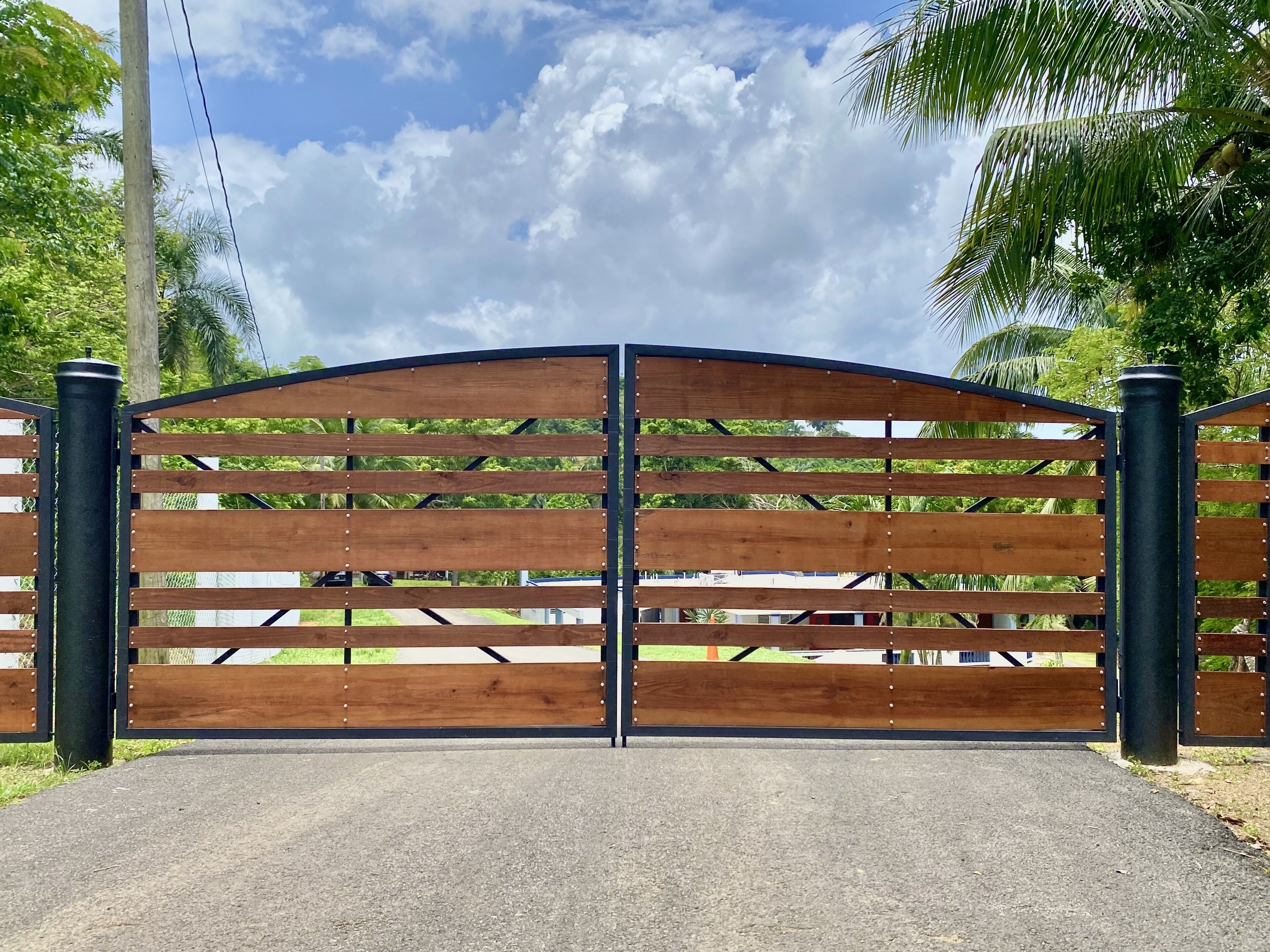 A gated entrance with a metal frame and wooden slats.