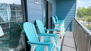 En balkong med turkosa Adirondack-stolar och en skylt med nummer 447 på väggen.