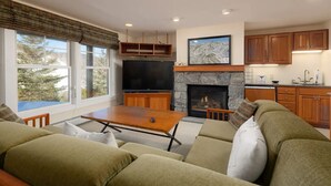 A modern living room with a fireplace, a television, and a dining area.