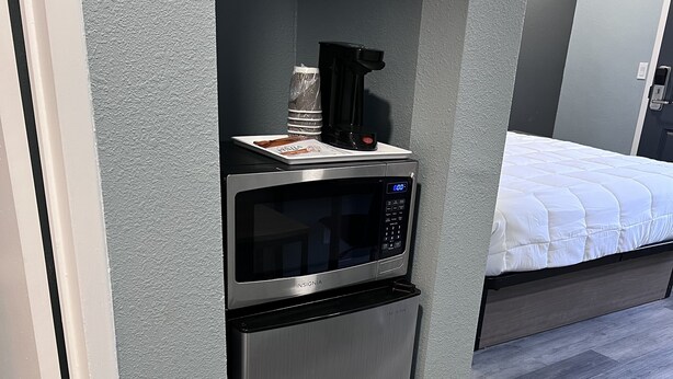 A compact kitchenette with a stainless steel microwave and oven, a coffee maker, and a small countertop. - 2 Room Suite - Indoor Pool and Spa - Walk to the Boardwalk - No Cleaning Fee! (Santa Cruz)