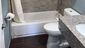 A bathroom with a bathtub, toilet, and shower curtain. - 2 Room Suite - Indoor Pool and Spa - Walk to the Boardwalk - No Cleaning Fee! (Santa Cruz)