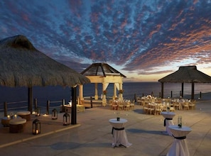 Dine under the stars by the ocean in a romantic gazebo setting.