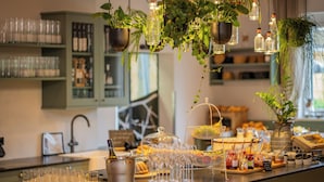 A buffet setup with various food items, a wine bottle, and a selection of glasses. - Königswieser Hof (Koenigswiesen)