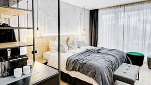 A modern hotel room with a bed, bedside table, and a coffee machine. - Königswieser Hof (Koenigswiesen)