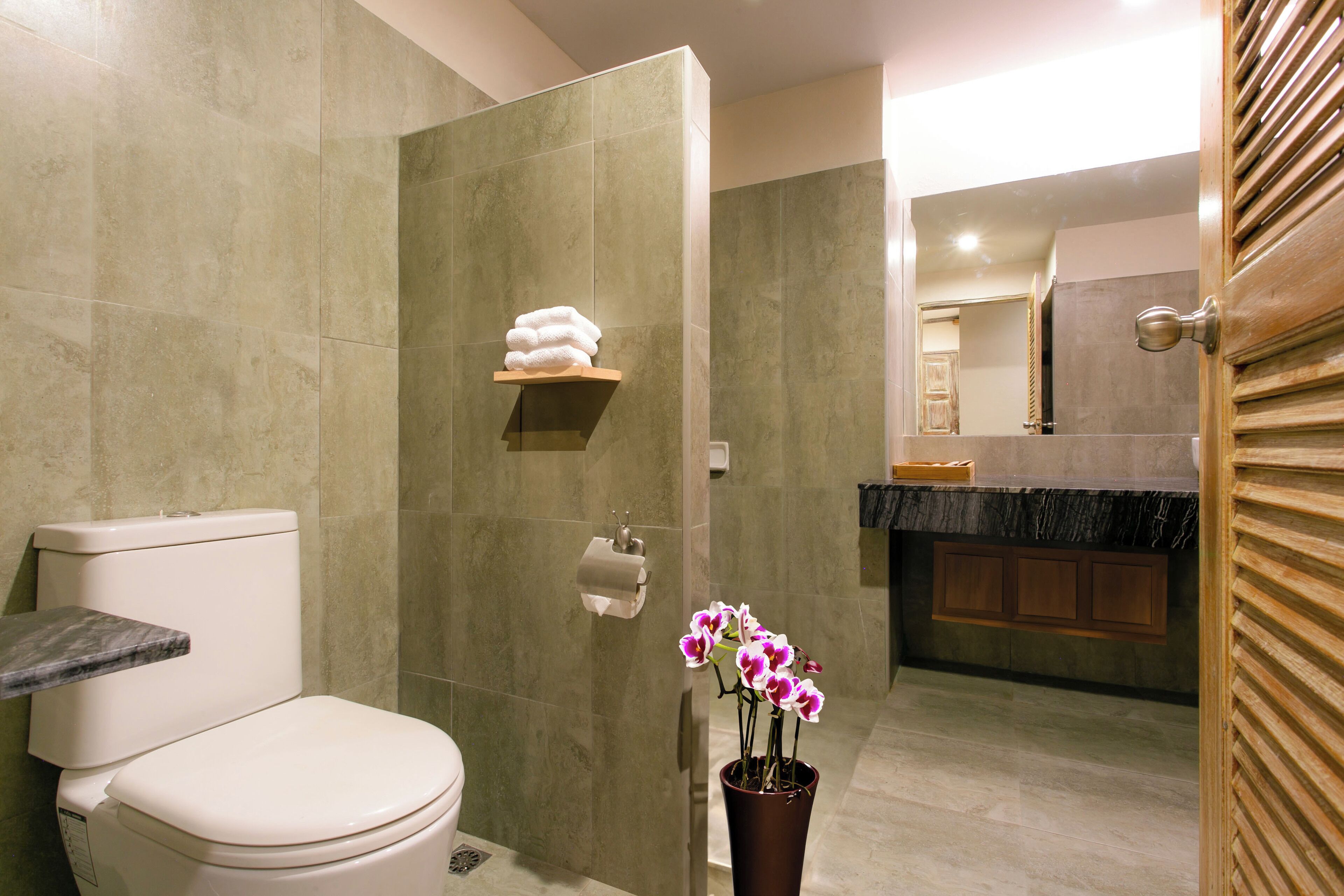 A modern bathroom with a toilet, a shower, and a sink.