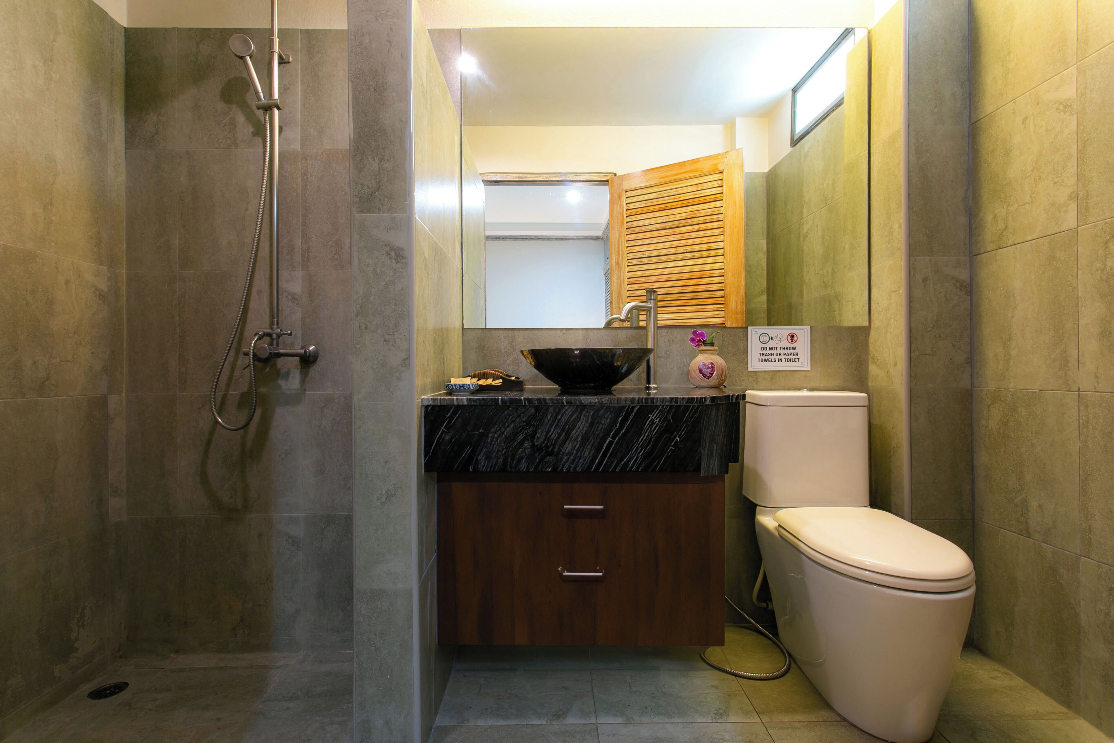 Ein Badezimmer mit Dusche, Toilette, Waschbecken und Schrank.