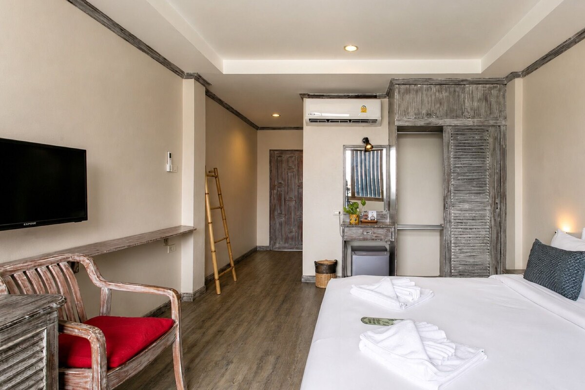 Una habitación de hotel con cama, televisión, escritorio y baño.