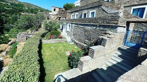 A stone building with a garden and a small stream. - PETRA Traditional HOUSE 2 (Ormos Korthiou)