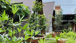 A garden area with potted plants and a pathway. - Nha cua Nep (Dien Hong)