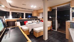 A modern interior with a dining area, seating, and a kitchen. - Cocoloco - Catamaran Lagoon 52F SAN BLAS (Narganá)