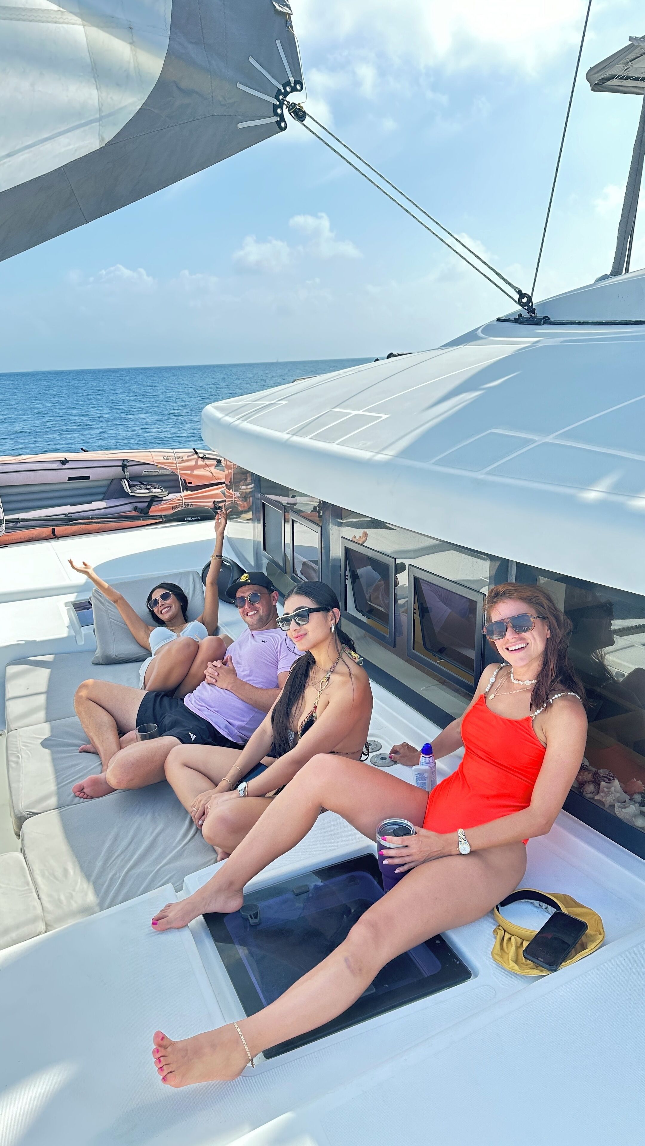 Un grupo de personas descansando en la cubierta de un barco, con vistas al mar.