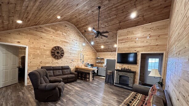 A cozy log cabin interior with a living room, kitchen, and fireplace. - New Cabin built in 2022. 2 minutes away from multiple trailheads!  Sleeps 8 (Rock)