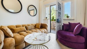 Ein Wohnzimmer mit einem braunen Sofa, einem violetten Sofa und einem Couchtisch aus Marmor.