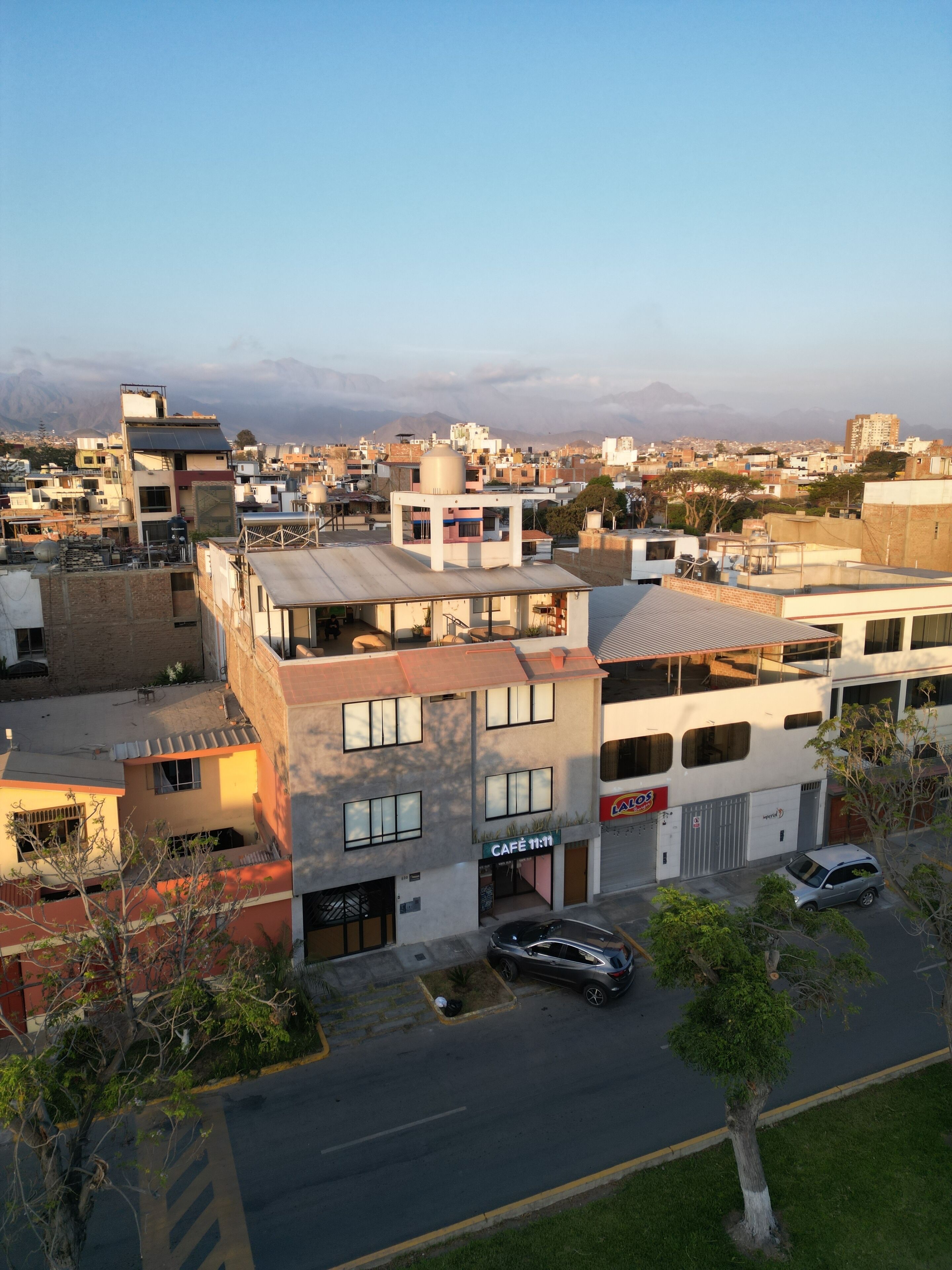 Un edificio de varios pisos con una cafetería llamada "CAFÉ 11:11" en la planta baja.