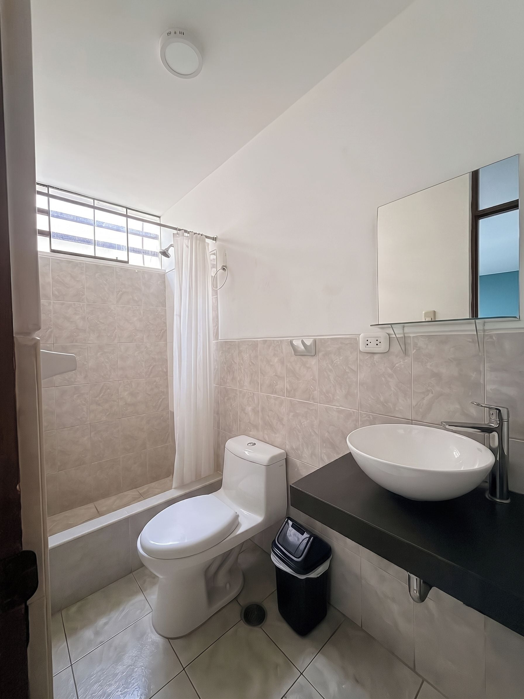A bathroom with a toilet, a sink, and a shower.
