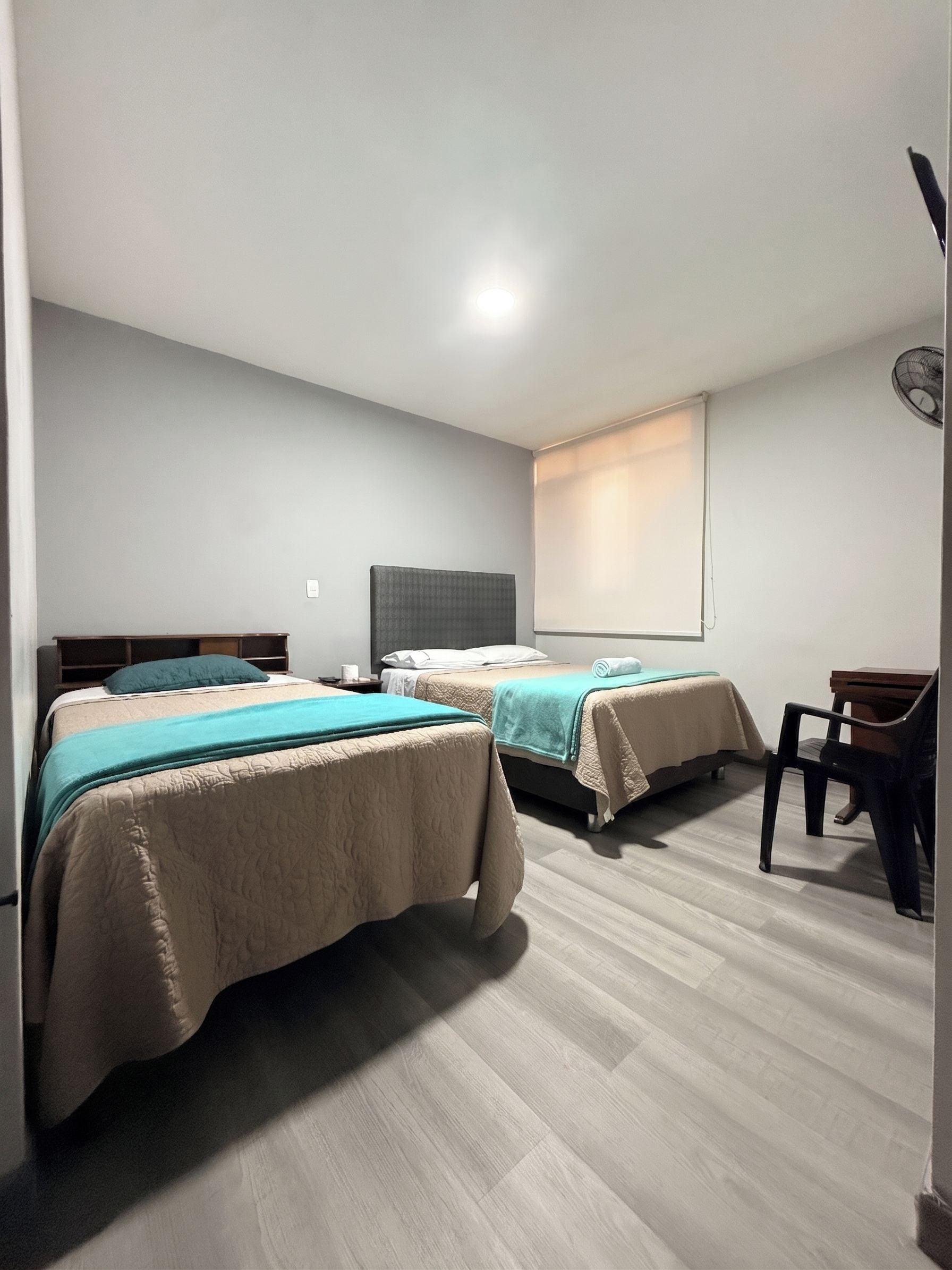 Una habitación de hotel con dos camas, un escritorio y una silla.