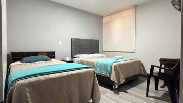 Una habitación de hotel con dos camas, un escritorio y una silla.