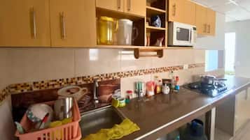Standard Apartment | Private kitchen | Fridge, highchair