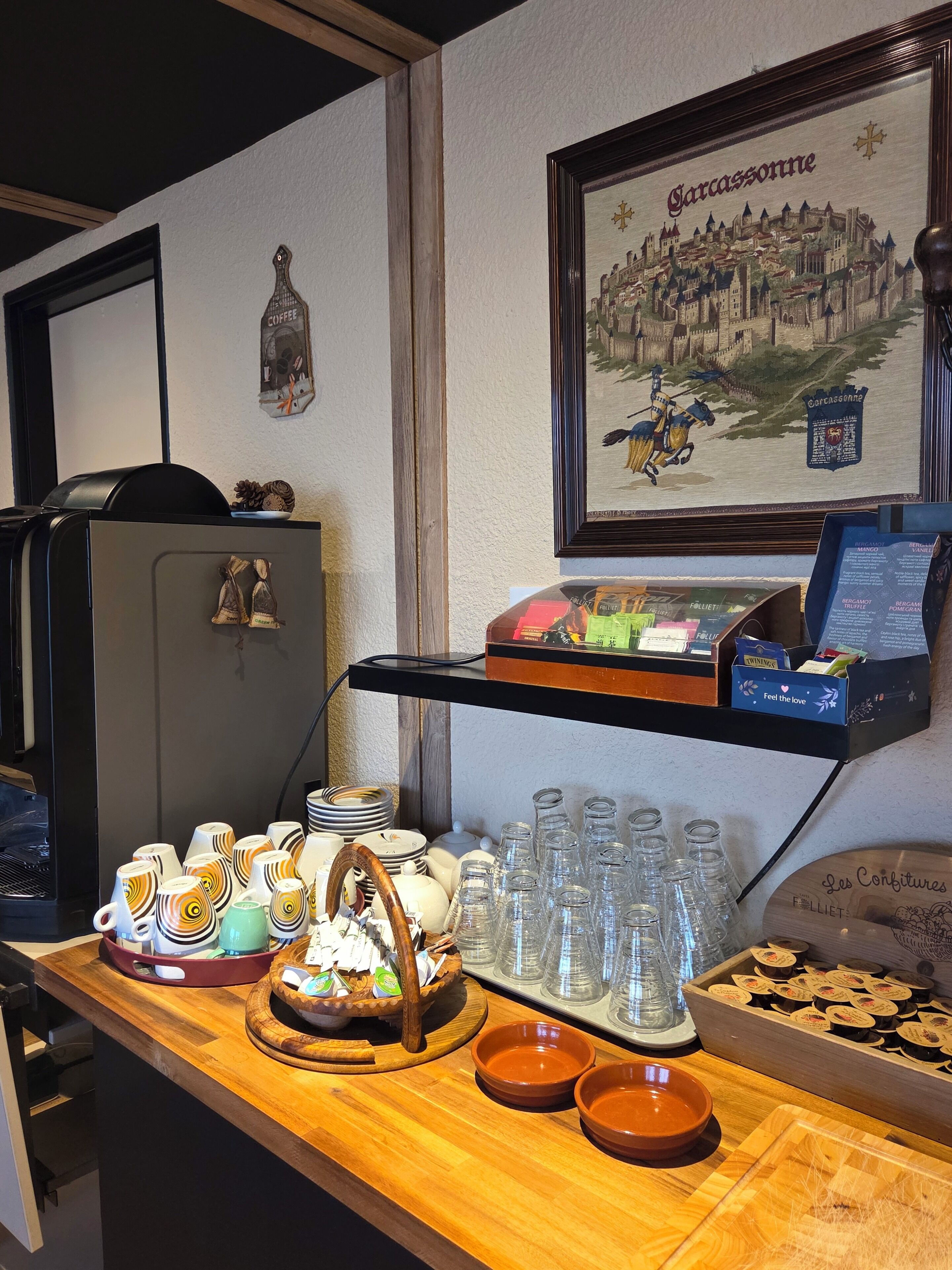 A buffet setup with various food items and a framed picture of a castle on the wall.