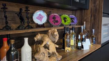 A bar area with a wooden countertop, wine bottles, decorative plates, and a lion sculpture.