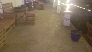 A dimly lit indoor space with wooden benches and tables, a patterned floor, and hanging plants. - Jalupon Health Resort (Atan)