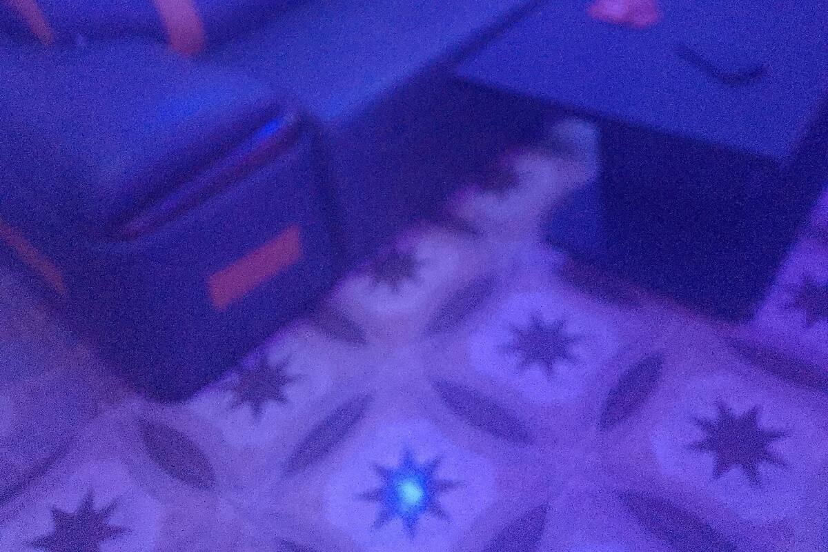A room with a patterned floor, a blue sofa, and a small table.