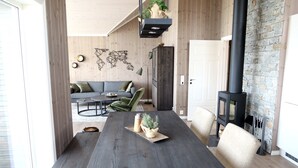En moderne stue med et mørkt træspisebord, en grå sofa og en stenspir