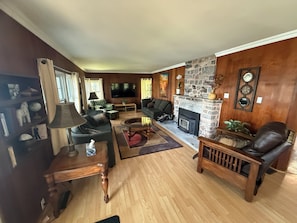 A living room with a stone fireplace, a television, and a sofa.