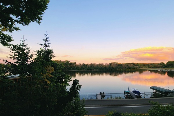 Stunning sunset with no homes across from you. Road resides between house & lake