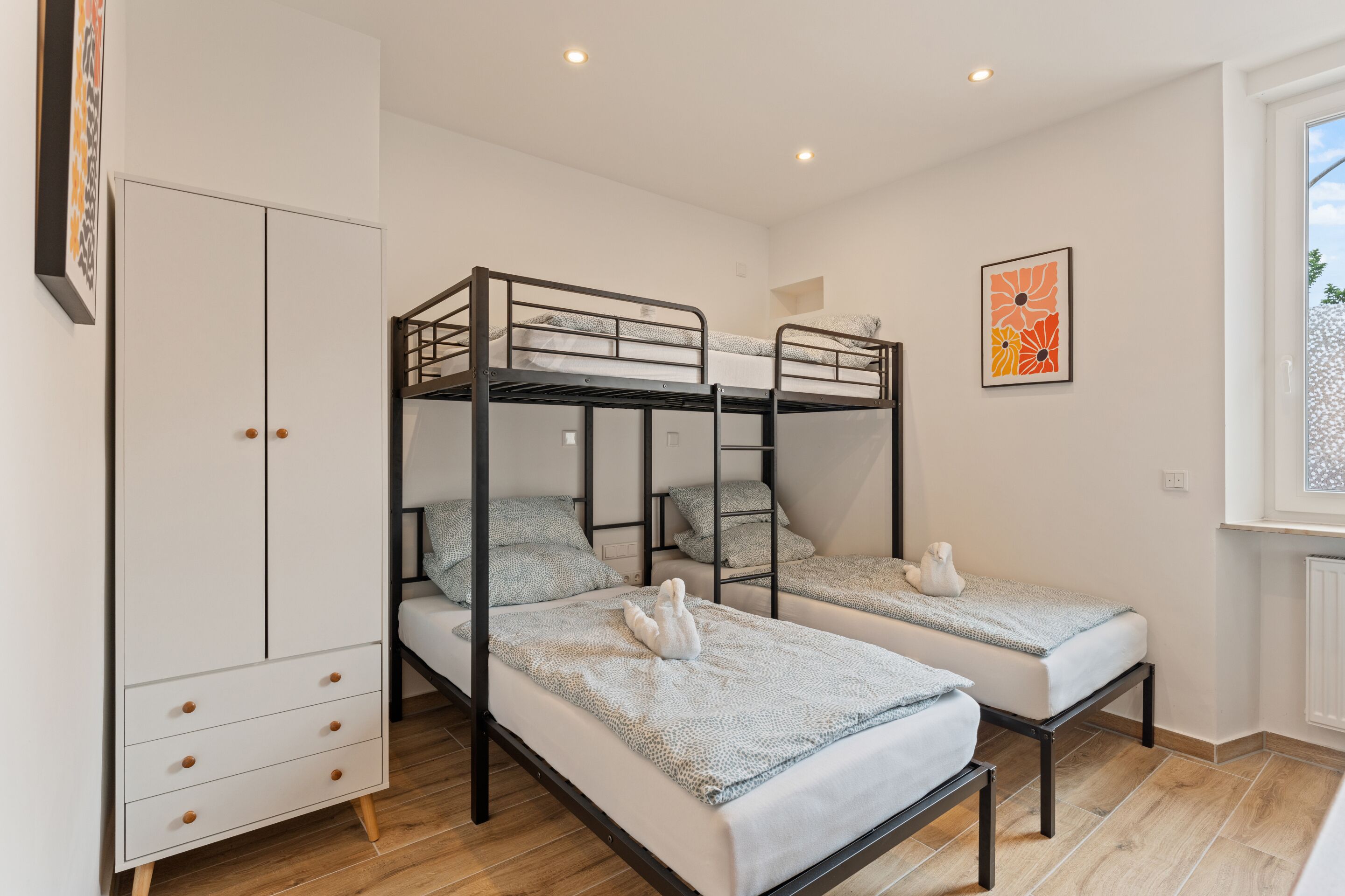 Un dormitorio con literas, un armario y una ventana con vistas.
