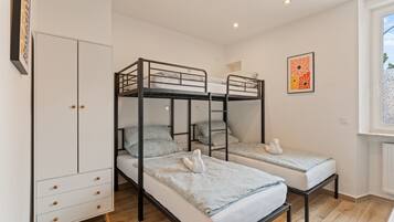 Un dormitorio con literas, un armario y una ventana con vistas.
