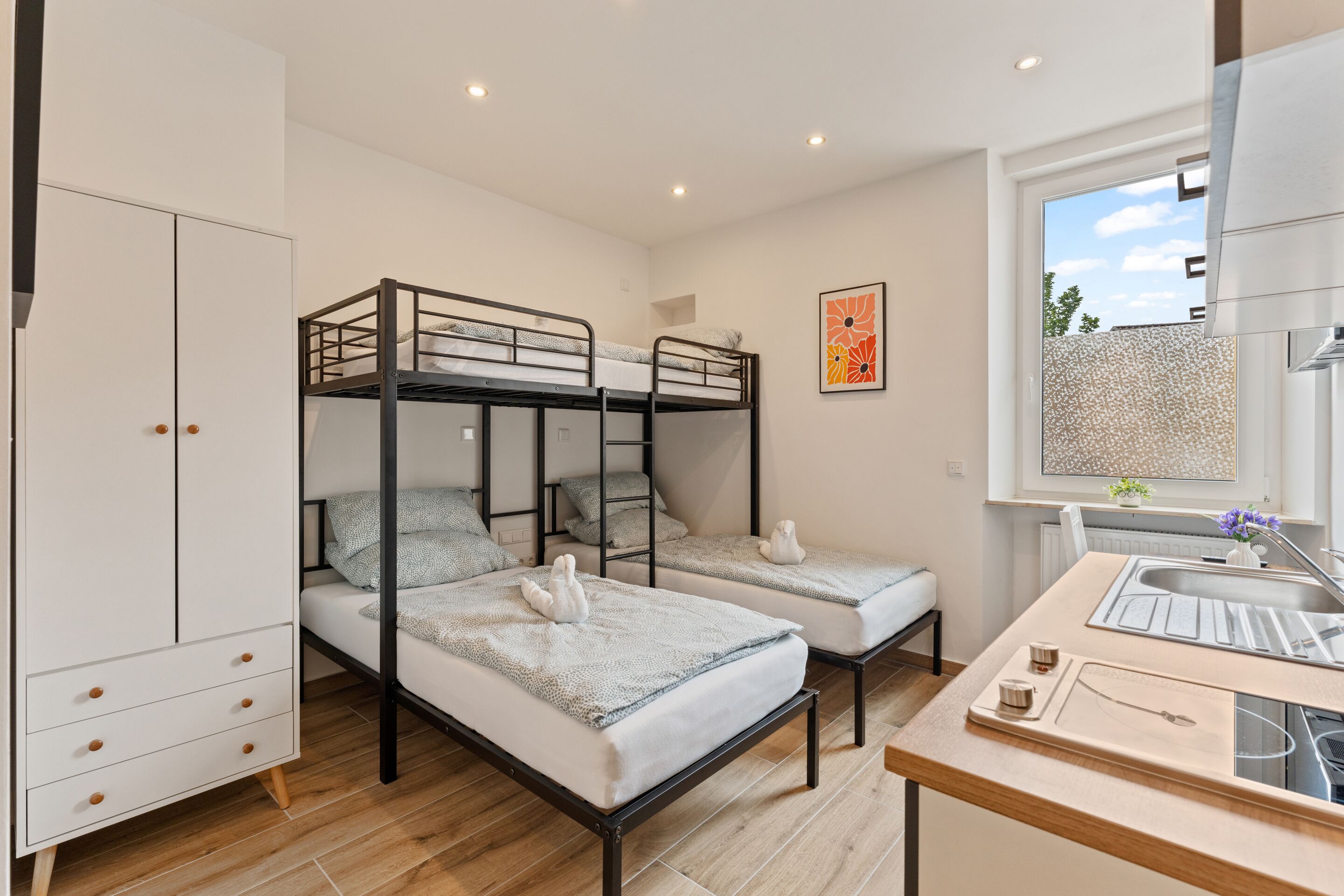 Een slaapkamer met een stapelbed, een bureau en een raam.