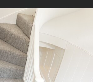 Stairs lead to a landing with a white railing.