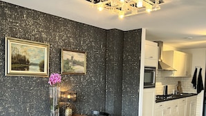 A dining area with a wooden table and black chairs, a vase with flowers, and two framed pictures on the wall. - Apartment overlooking the beautiful Brouwersgracht canal in Amsterdam centre (Amsterdam)