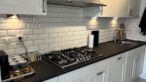 A modern kitchen with white cabinets, a black countertop, and a stainless steel range hood. - Apartment overlooking the beautiful Brouwersgracht canal in Amsterdam centre (Amsterdam)