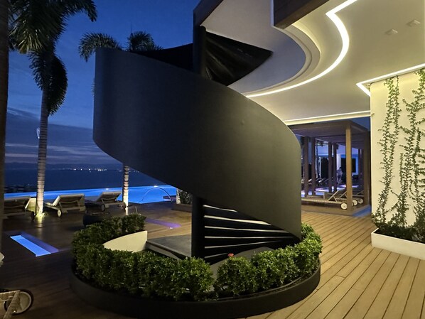 A modern outdoor area with a spiral staircase, lounge chairs, and a pool. - Largest PV Rooftop Heated Pool, Oversized Terrace Oasis, Zona Romantica, 2 Brm (Puerto Vallarta)