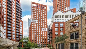 Un complexe résidentiel urbain moderne, composé de plusieurs immeubles de grande hauteur, doté de balcons et de grandes fenêtres.